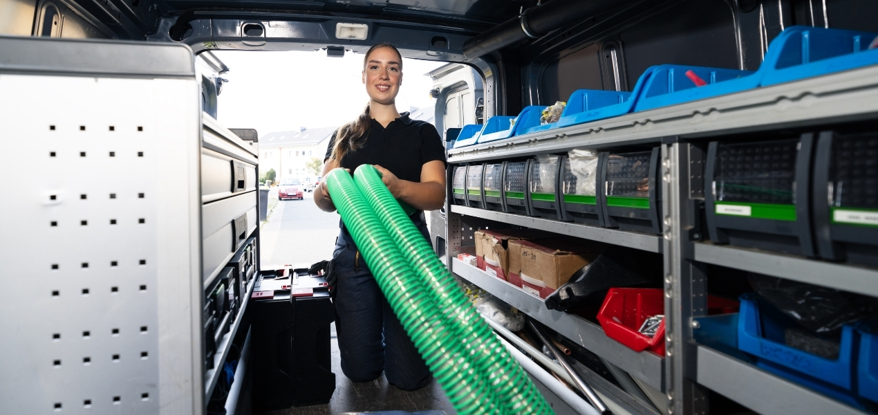 Heizungsbauerin holt Equipment aus dem Fahrzeug
