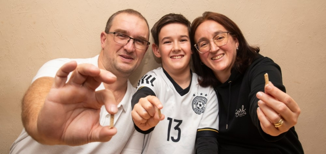 Familie schaut in die Kamera mit Pellets in den Händen