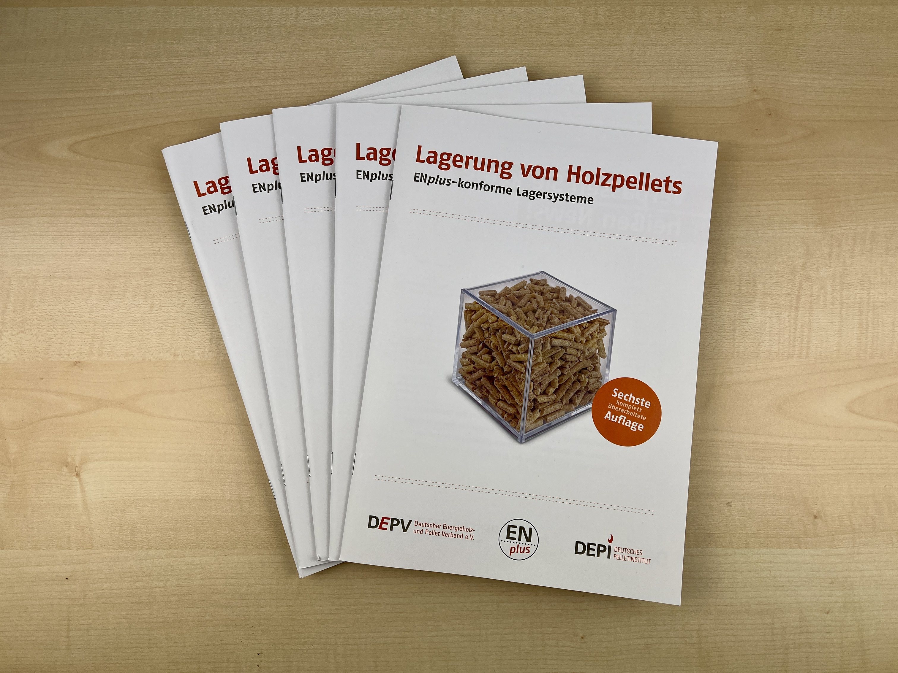 Fünft Exemplare der Broschüre Lagerung von Holzpellets aufgefächert auf einem Tisch